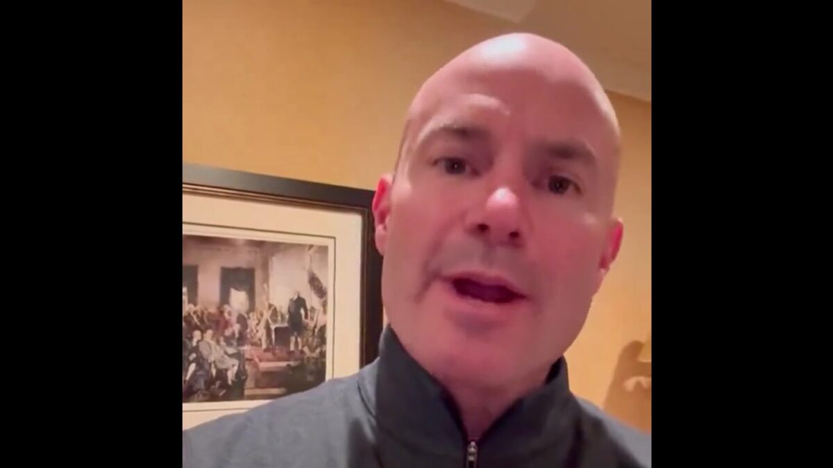 A bald headed man talking to his phone camera