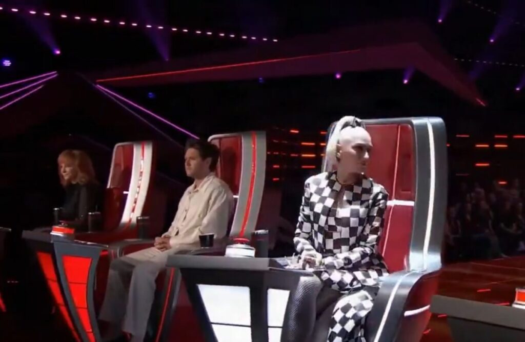 Three celebrities sitting in chairs on The Voice tv show.